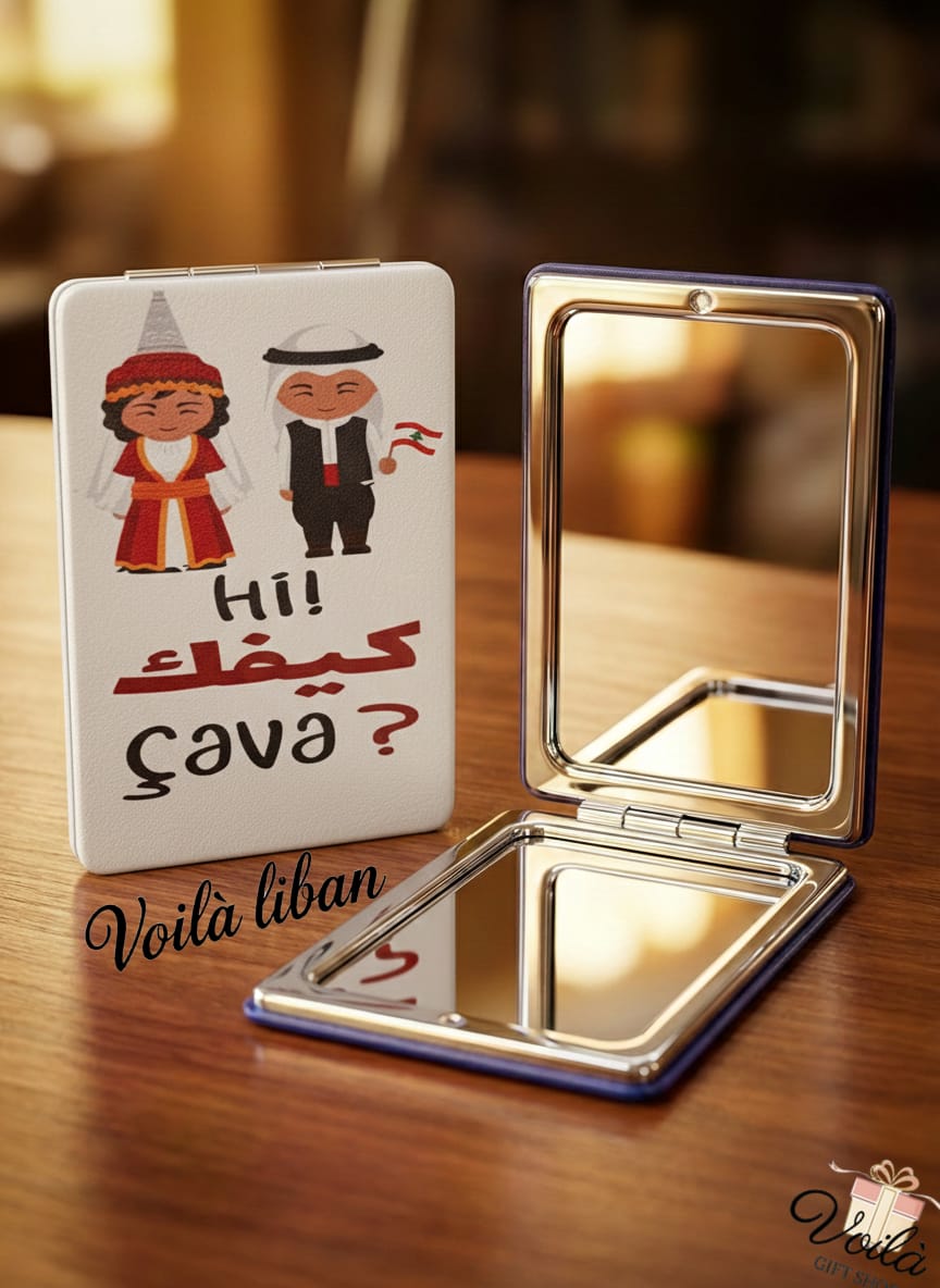 Compact mirror with cartoon characters and text on a wooden surface