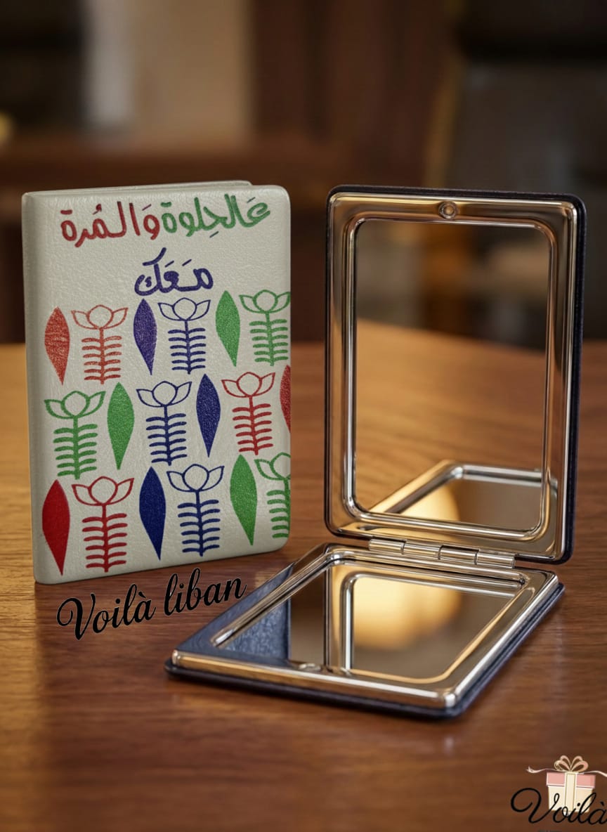 Compact mirror with a colorful case on a wooden surface