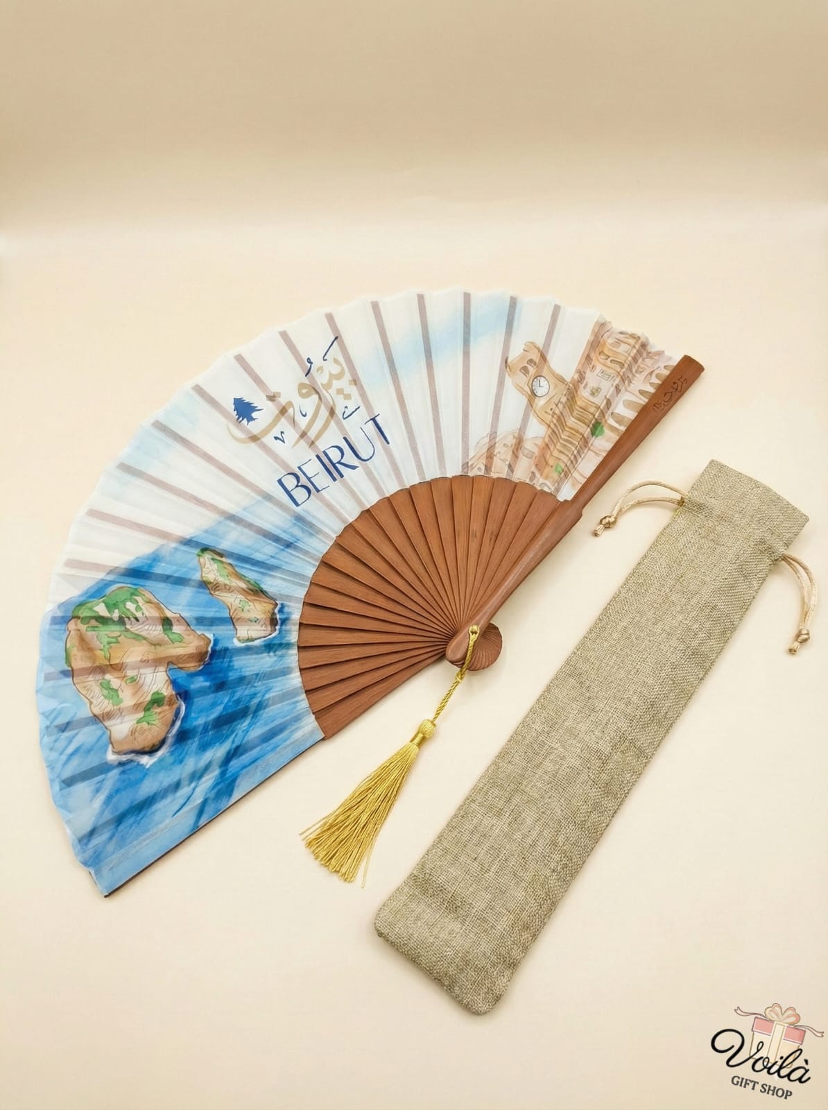 Decorative fan with travel-themed design and matching pouch on a beige background