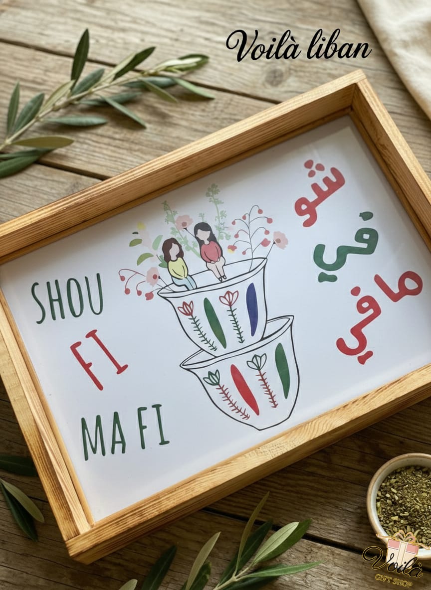 Decorative sign with Arabic text and illustrations in a wooden frame on a wooden surface.