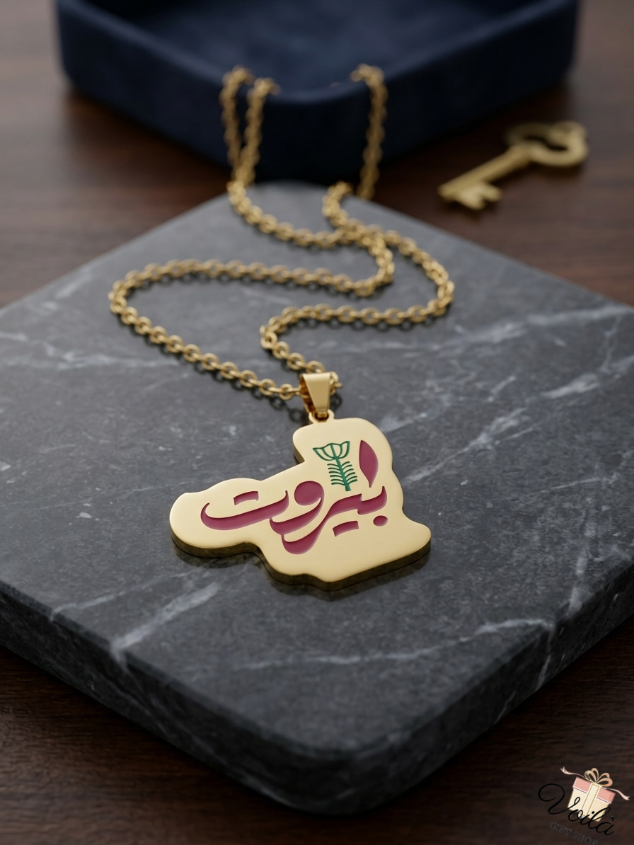 Gold-plated Lebanon map necklace featuring Beirut Arabic calligraphy on a marble display
