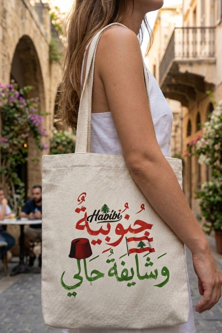 Woman carrying a natural canvas tote bag with Lebanese flag, tarboush, and Arabic calligraphy