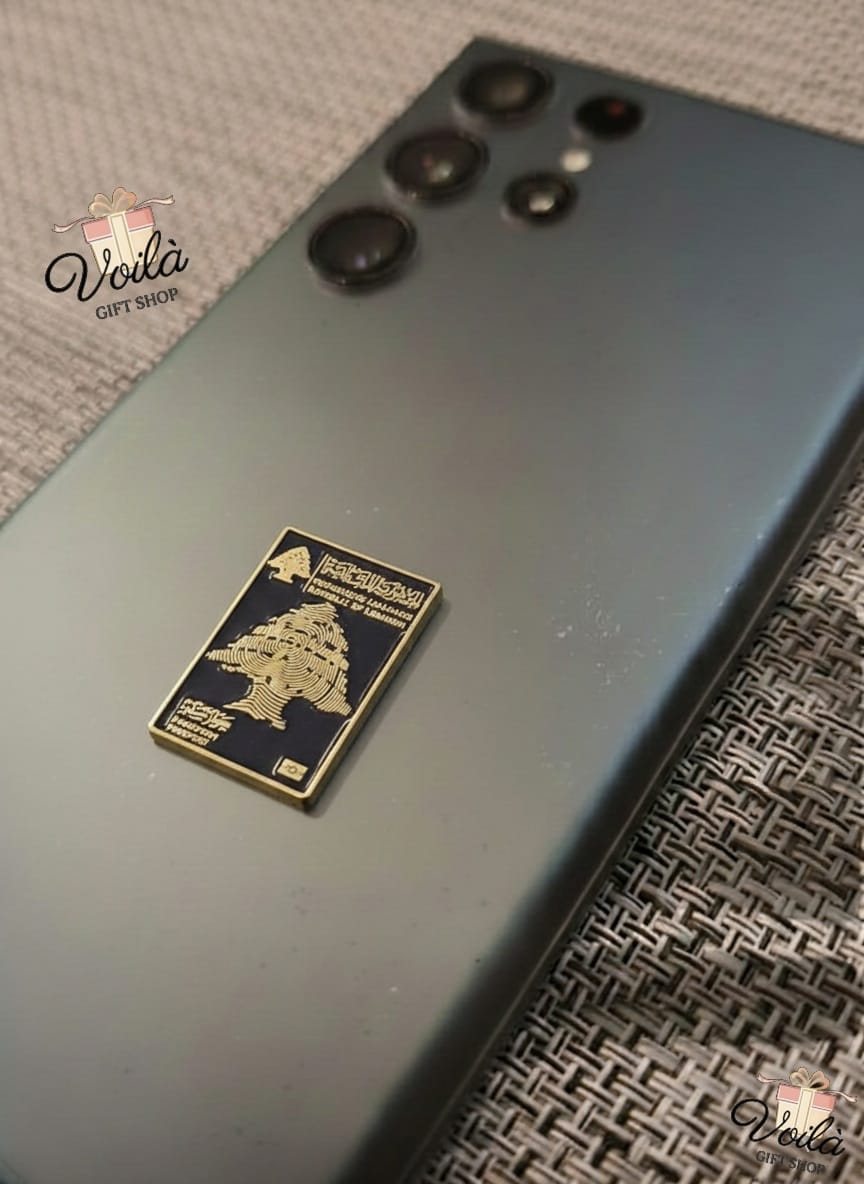 Smartphone with a decorative metal tag on a textured surface
