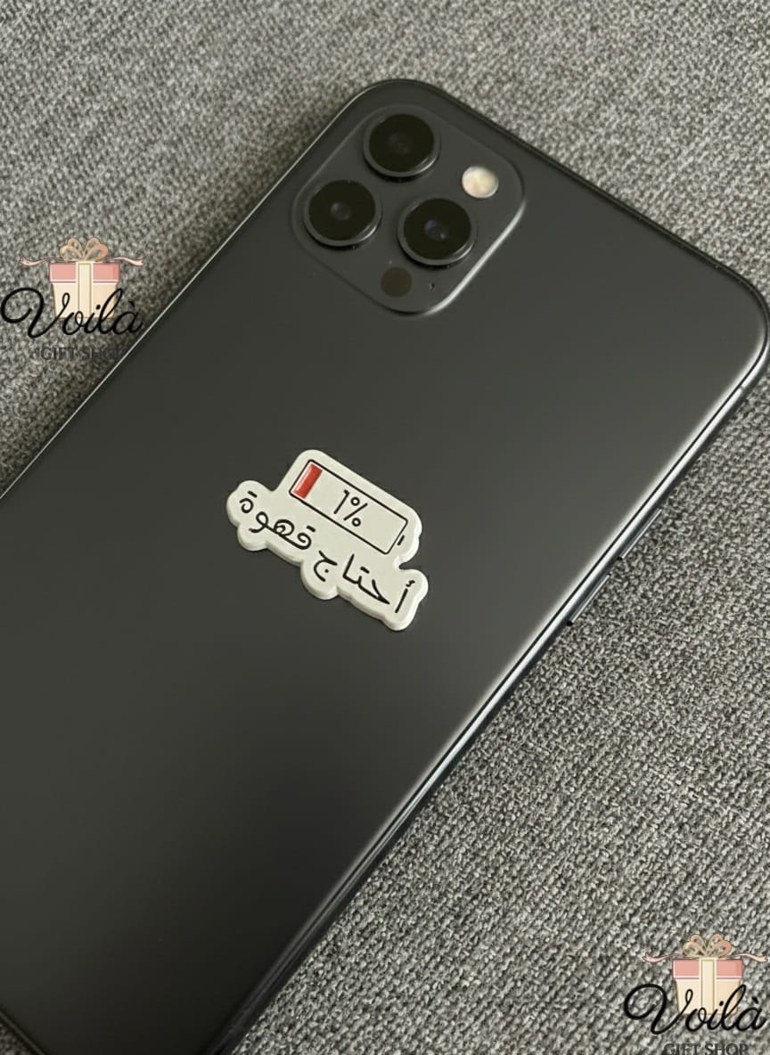 Black smartphone with a coffee-themed sticker on a textured gray surface