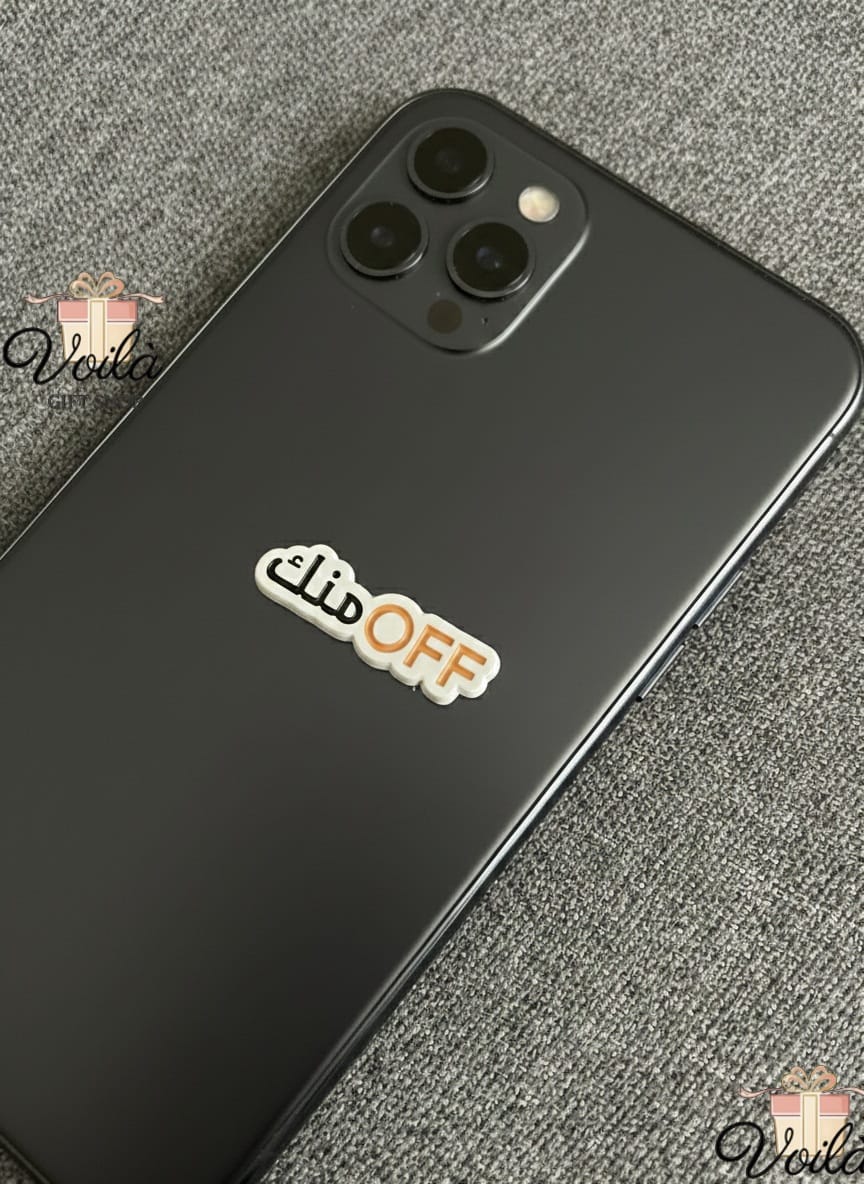 Black smartphone with 'Mute Off' sticker on a gray textured surface