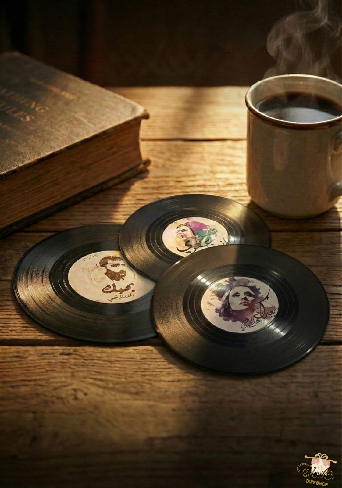 Vinyl record coasters with artistic designs on a wooden surface with a steaming mug of coffee and an open book.