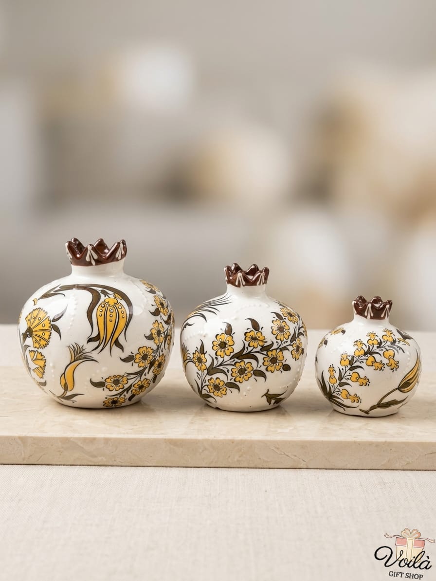 Set of three premium ceramic pomegranate vases in cascading sizes, featuring elegant hand-painted brown and yellow botanical and tulip motifs with a glazed brown scalloped crown, resting on a light marble surface.