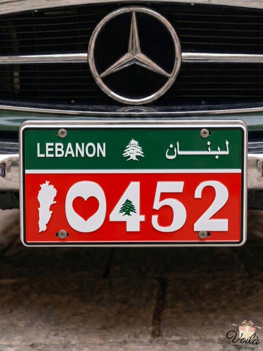 Red and green decorative Lebanese license plate mounted on a classic car, prominently displaying the patriotic number 10452 with a heart, the national Cedar tree, and the white silhouette of the Lebanon map.
