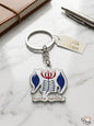 Keychain with a logo on a marble surface with a notebook and pen.