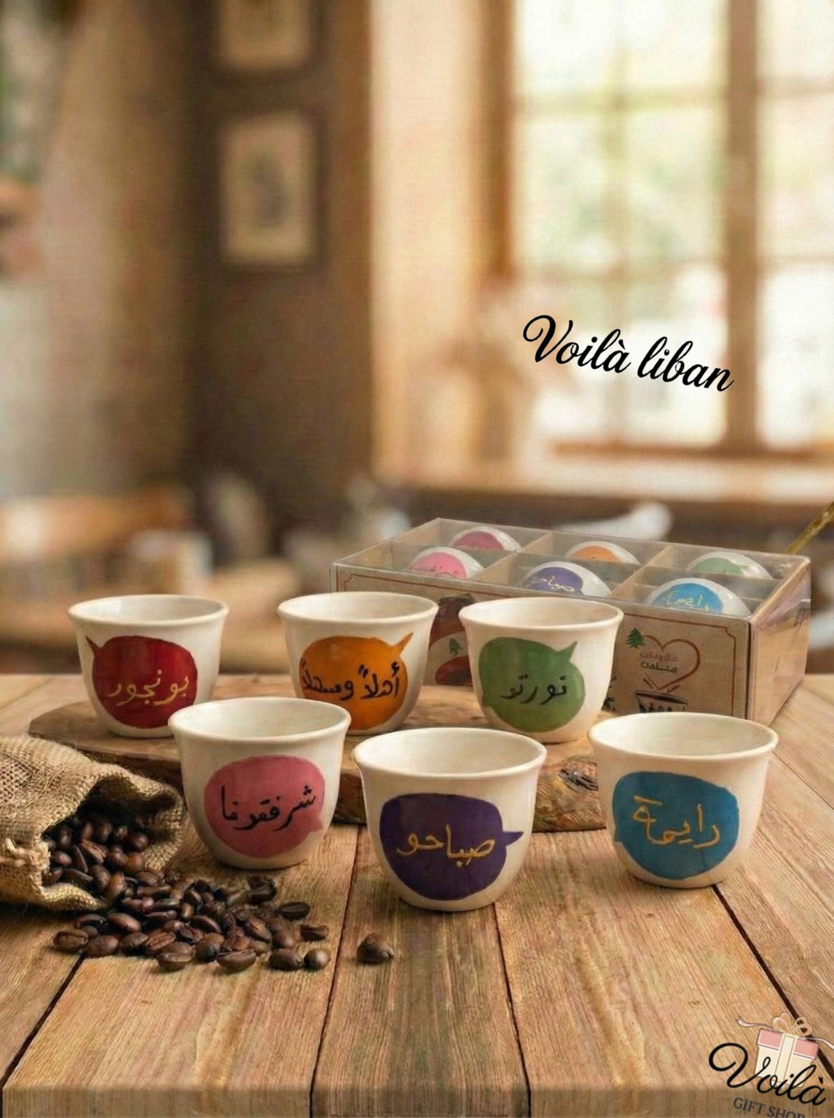 Set of colorful coffee cups with Arabic text on a wooden table, featuring the brand 'Voila Liban'.