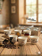 Set of ceramic cups with various designs and text on a wooden table, with 'Voila Liban' branding.