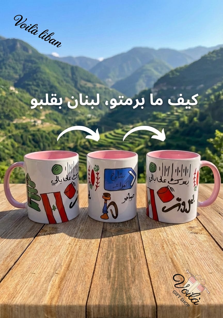 Three mugs with designs and text on a wooden surface with a mountainous landscape in the background.