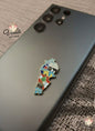 Colorful map pin on a phone case with 'Voila Gift Shop' branding.