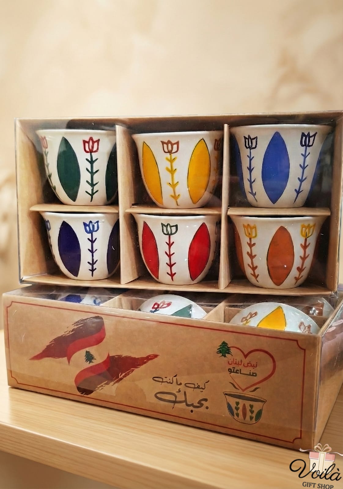 Set of six colorful ceramic cups in a wooden box with decorative patterns.