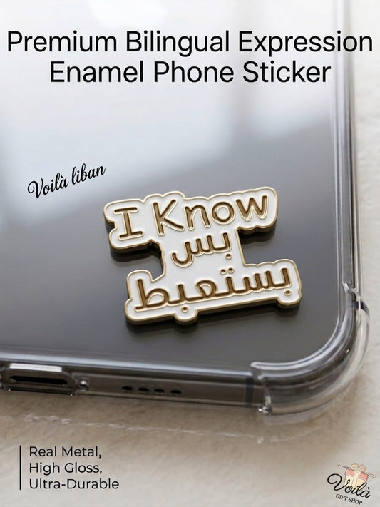 Premium white and gold metal enamel phone sticker featuring a humorous Lebanese bilingual phrase that reads "I Know" in English, followed by the Arabic text "بس بستعبط" (bas basta3bet), affixed to a clear phone case.