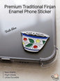 Premium metal enamel phone sticker shaped like a traditional Lebanese coffee finjan with a classic floral pattern in green, red, and yellow, featuring the Arabic phrase "عالحلوة والمرة" written along the top rim, attached to a clear phone case.