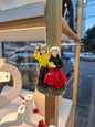 Decorative figurines of a couple on a stand with a blurred outdoor background