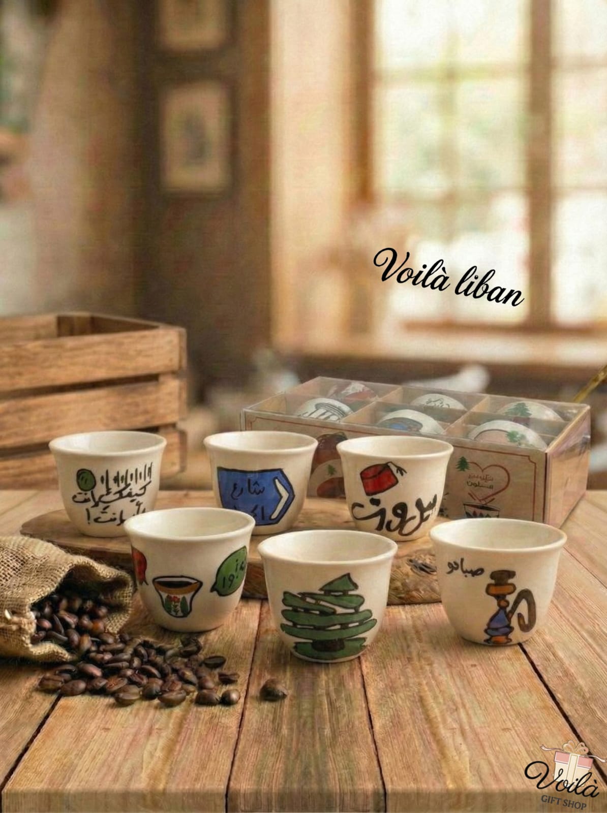 Set of hand-painted ceramic cups on a wooden table with 'Voila Liban' branding.