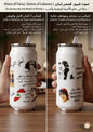 Two cans with artistic illustrations and text, held by a hand on a wooden surface.