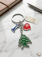 Keychain with tree, heart, and flag charm on a marble surface