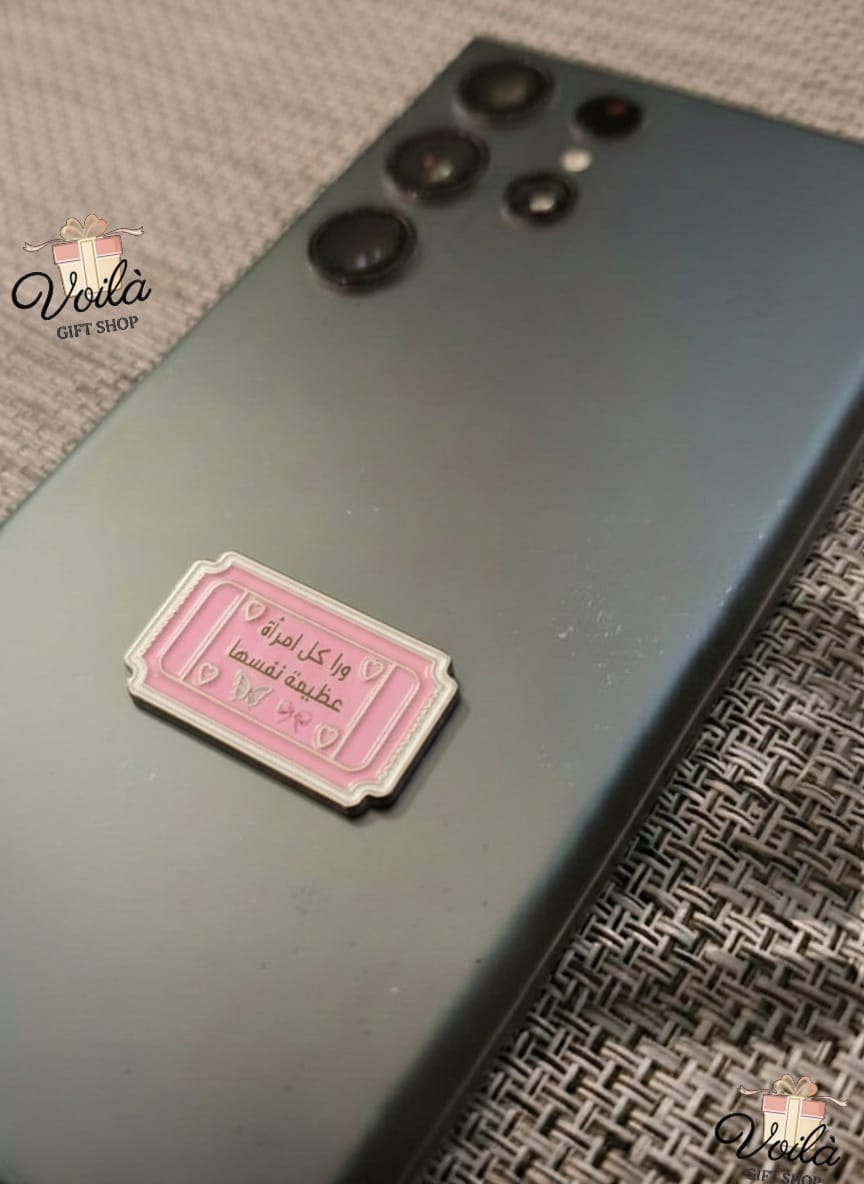 Phone case with a pink label on a textured surface, branded 'Voila Gift Shop'.