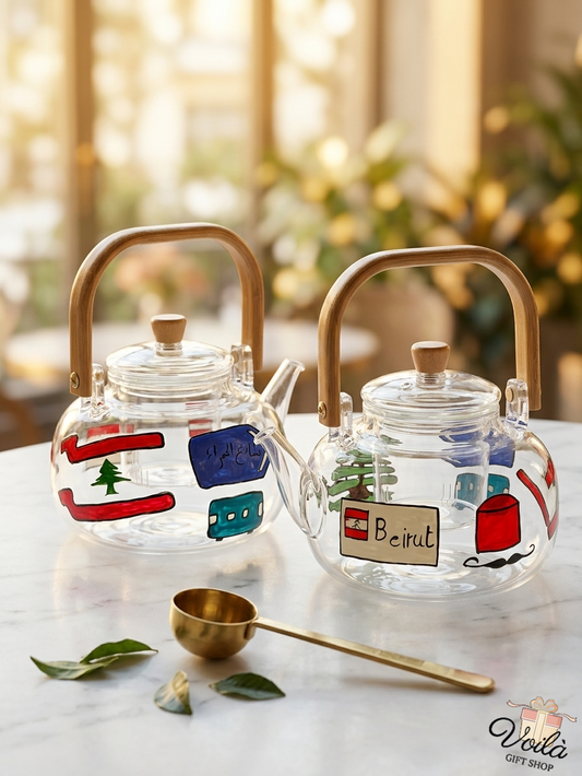 Two hand-painted glass teapots with Lebanese heritage motifs and bamboo handles