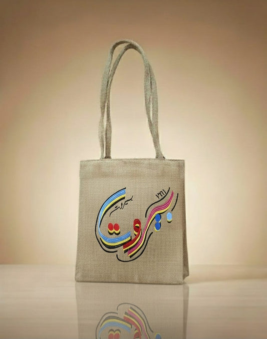 Textile bag with colorful Arabic calligraphy on a beige background