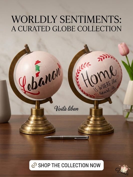 Soft blush pink decorative globe featuring a Lebanon map and 'Home is where the heart is' typography, resting on a heavy brass and copper stand.