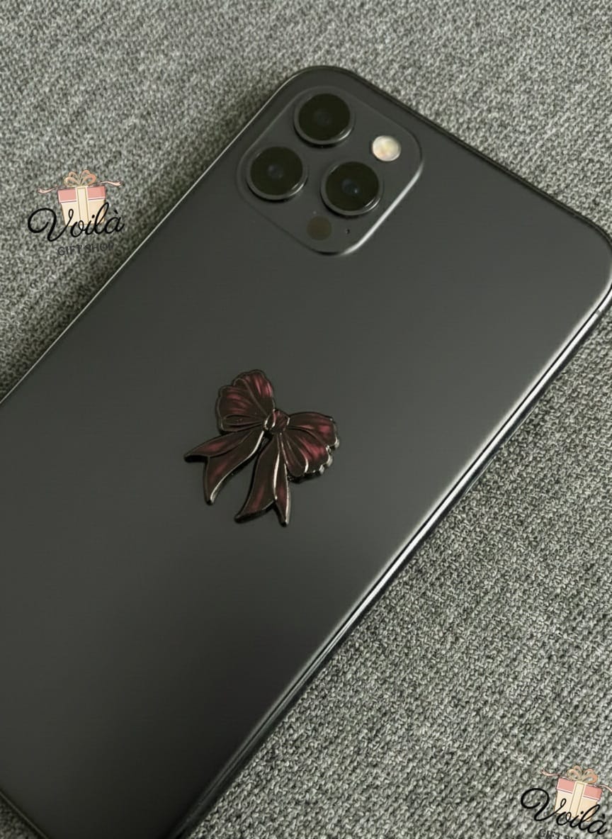 Phone case with a decorative bow on a textured surface
