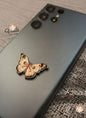 Butterfly-shaped phone case on a smartphone with 'Veila' branding.