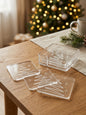 Clear acrylic Christmas tree coasters with matching holder on a wooden table
