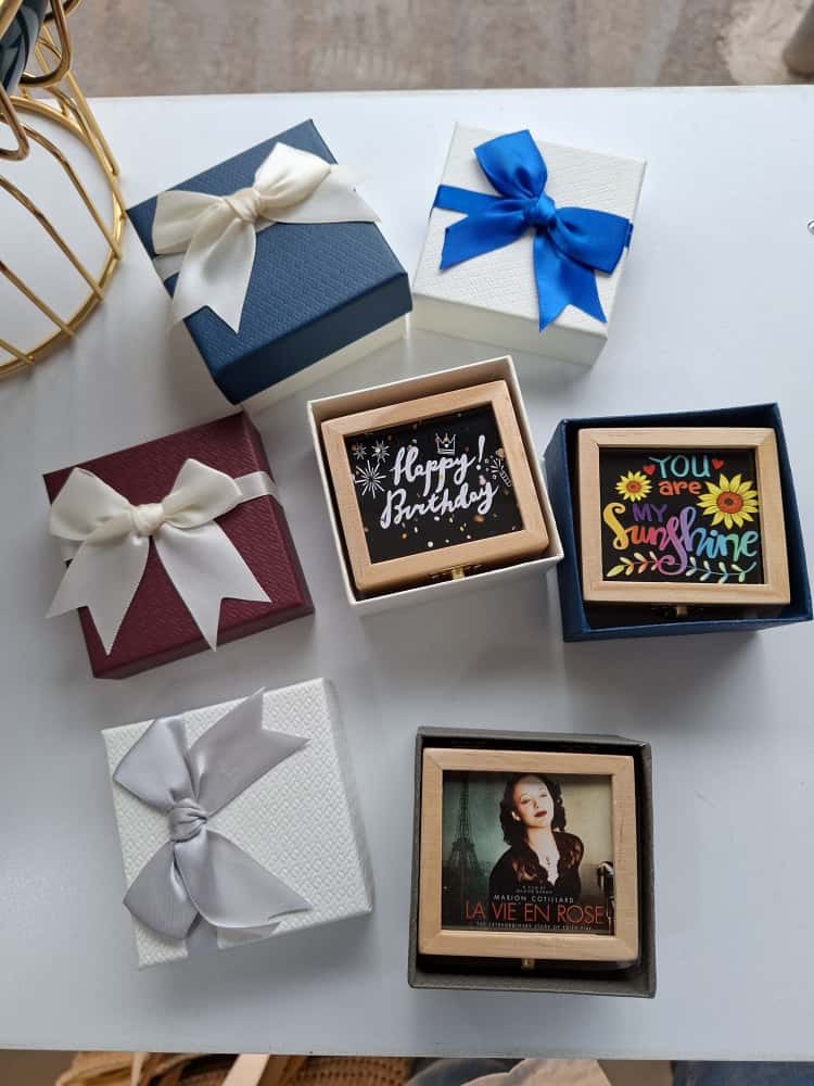 Collection of gift boxes with bows and decorative text on a white surface