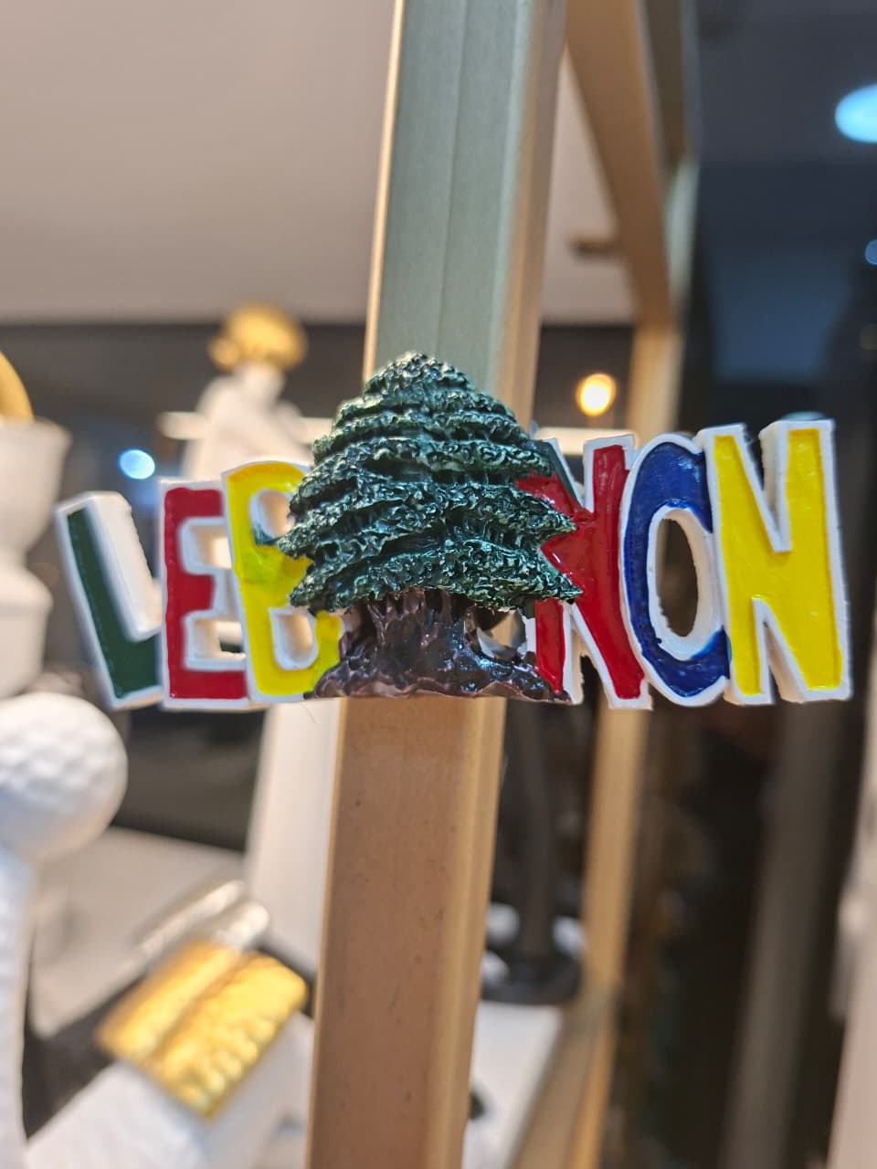 Colorful 'LE BON' sign with a tree graphic on a blurred background
