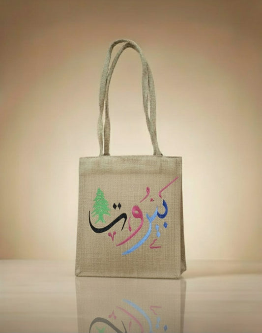 Jute bag with colorful text and design on a beige background