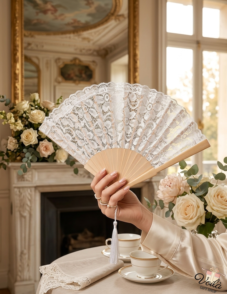 Hand holding an elegant white lace folding fan with a wooden frame and white tassel