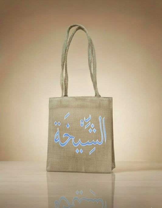 Beige tote bag with Arabic text on a beige background