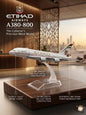 Model airplane on a stand with Etihad Airways branding in an indoor setting.