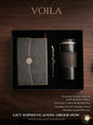 Gift set with leather journal, pen, and insulated tumbler in a black box on a wooden surface.