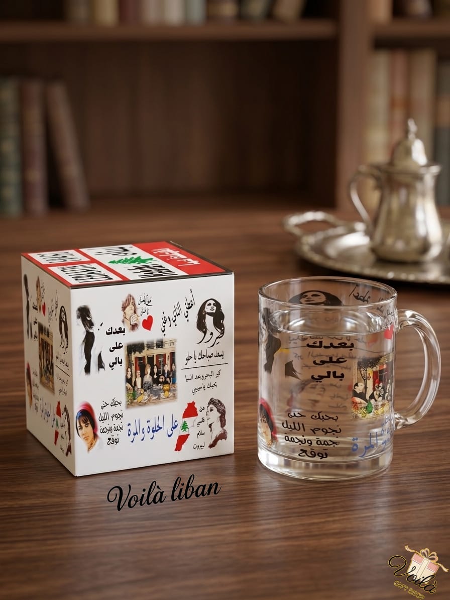 Clear glass mug with decorative design on a wooden table next to its packaging, with 'Voila Liban' branding.