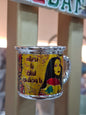 Decorative glass mug with a colorful design and text on a blurred background