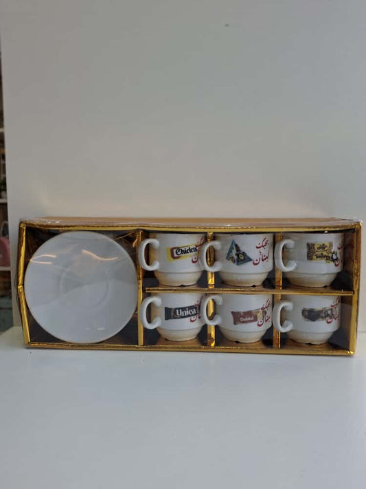 Set of six small cups with various designs in a gold box on a white background