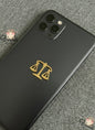 Black phone case with gold Libra zodiac symbol on a gray textured surface