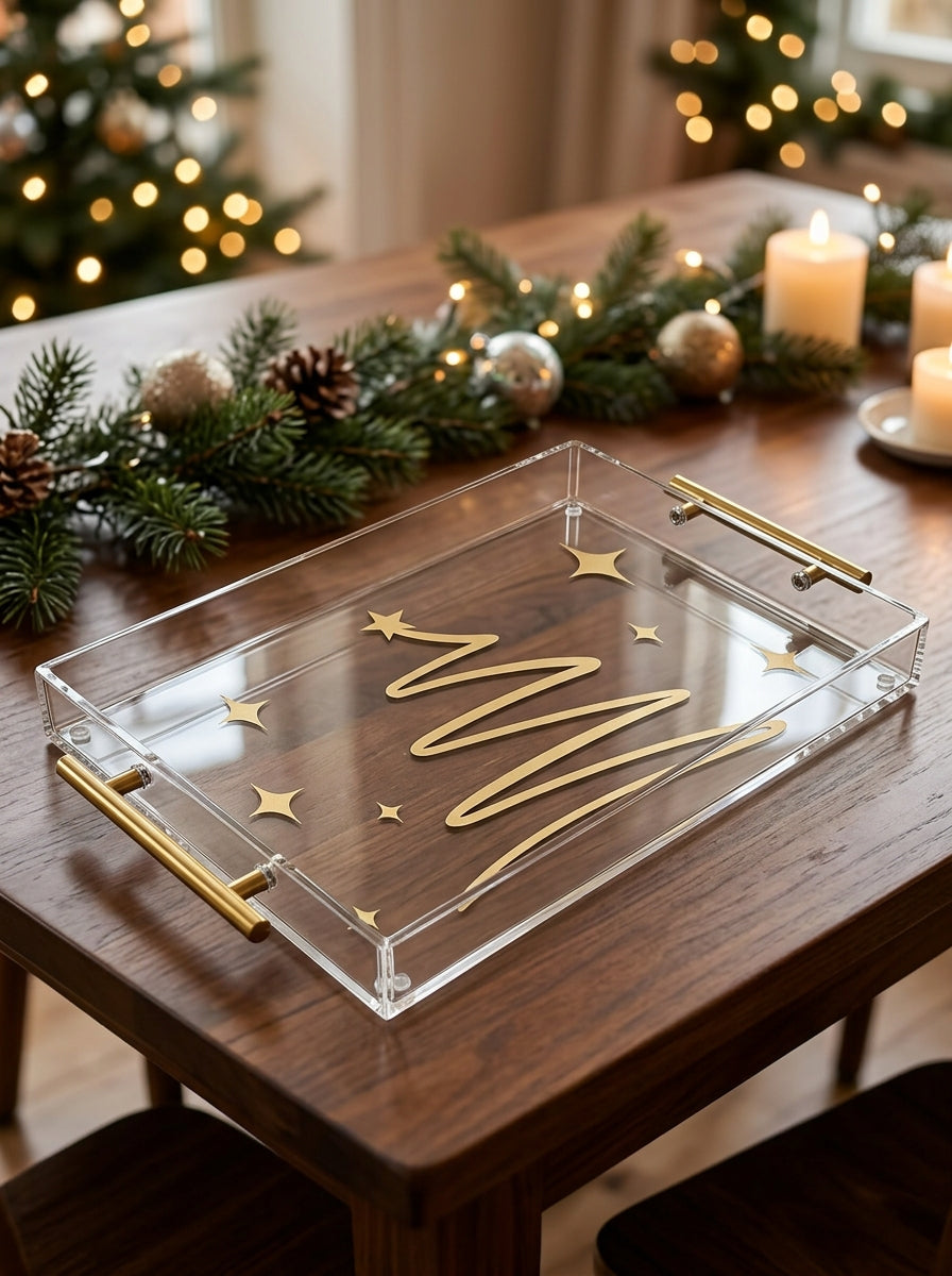 Clear acrylic holiday tray with golden Christmas tree design and gold handles on wooden table