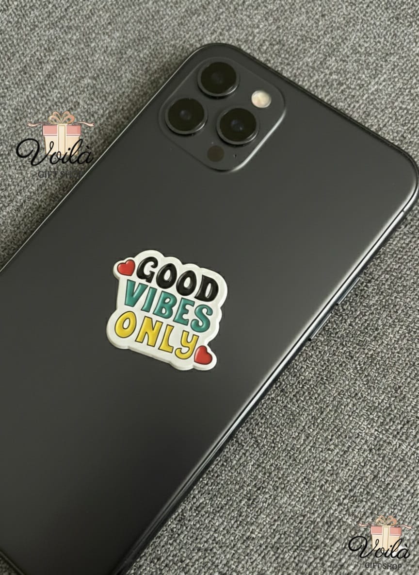 Phone case with 'Good Vibes Only' sticker on a textured surface