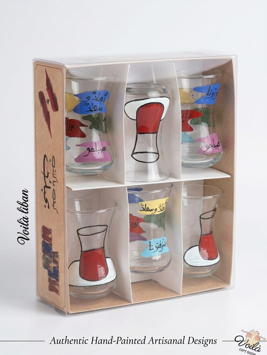 Set of six authentic hand-painted Lebanese glass tea cups featuring traditional red tea cup illustrations and colorful banners with Arabic greeting calligraphy like Ahlan wa Sahlan, in a premium display box.
