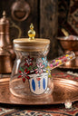 Hand-painted glass rakweh with a bamboo lid and dried flower handle on a copper tray