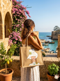 Woman holding a hand-painted jute tote bag overlooking a historic Lebanese harbor