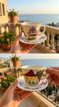 Hand-painted Lebanese ceramic coffee cup and saucer featuring traditional red-roofed house design