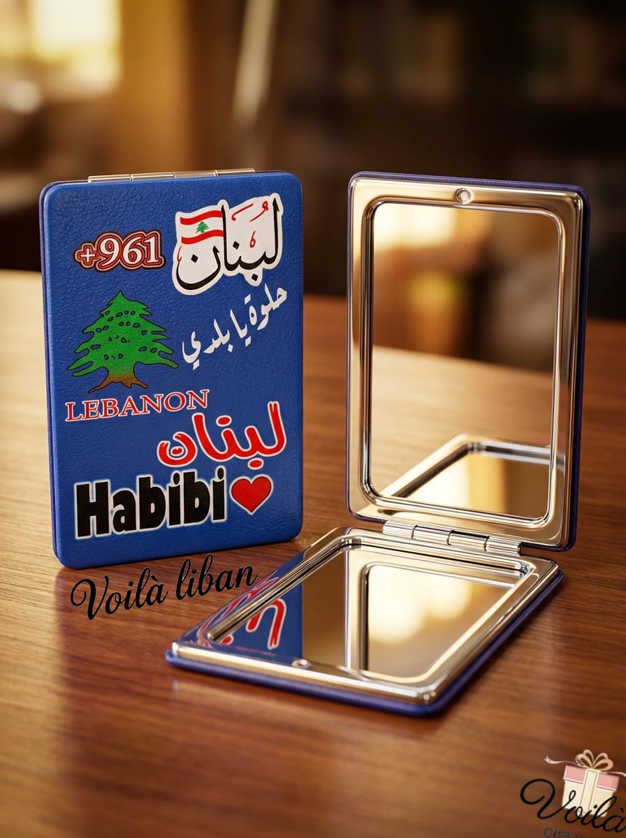 Compact mirror with Lebanese design on a wooden surface