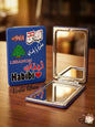Compact mirror with Lebanese design on a wooden surface
